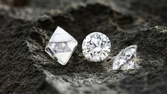 Rough and Polished diamonds on a bed of kimberlite